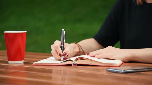 Woman Writing On Note Pad