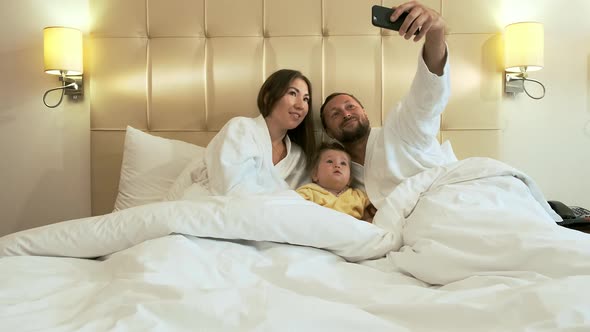Happy Family in Bed Preparing for Bed in the Evening alt