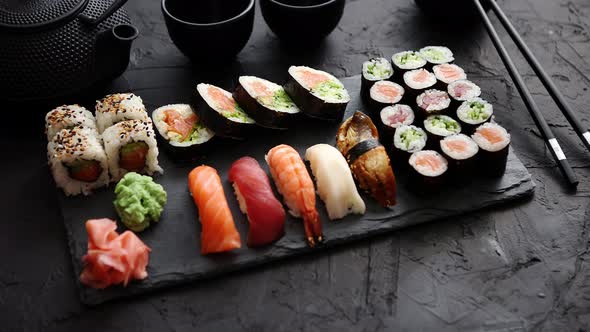 Assortment of Different Kinds of Sushi Rolls Placed on Black Stone Board alt