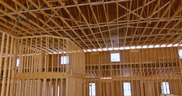 An Interior View of a Wooden Building the Beam Framework is Supported By Wooden Truss Rafters alt