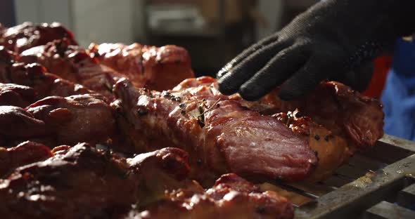 The Worker Takes The Baked Meat Out Of The Oven And Places It On A Baking Sheet To Cool alt