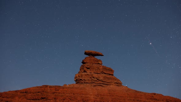 Time lapse of the night sky behind the rock formation of Mexican Hat alt