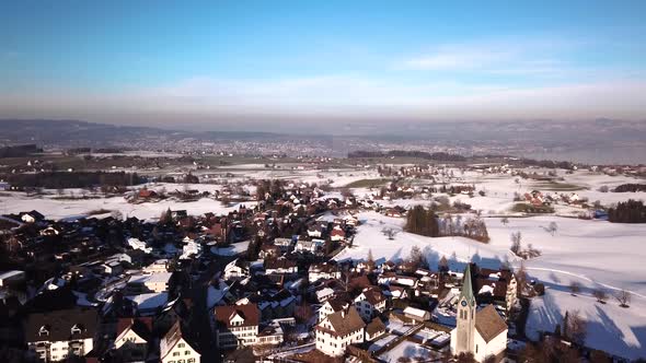 Beautiful aerial view over a small village on a hill next to the lake of zurich alt