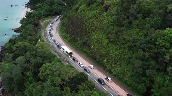 Aerial flying over traffic stopped on way down to beach, Ubatuba, Brazil alt