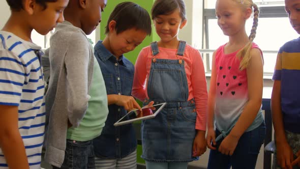 Group of multi-ethnic school kids using digital tablet in classroom at school 4k alt