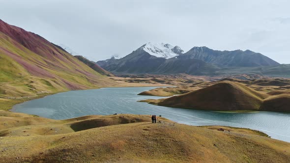 Aerial Shot of a Beautiful Valley with Surrounding Mountains Two People on Top of Hill alt
