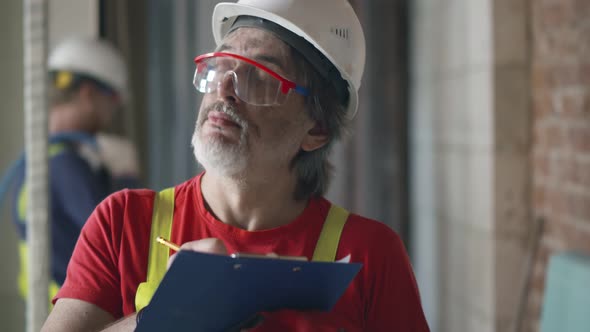 Building Inspector in Safety Gear Checking Construction Site alt