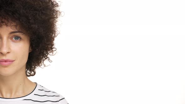 Halfside Portrait of Feminine Adorable Female with Dark Curly Hair Looking on Camera Smiling with alt