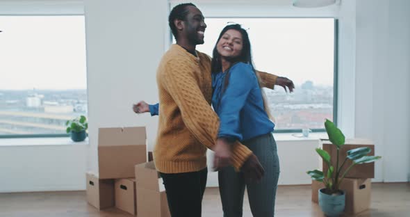Young couple hug each other in their new home alt
