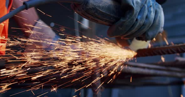 Close-up Slow Motion. Side View of Male Hands Cutting Metal with Grinding Machine. alt