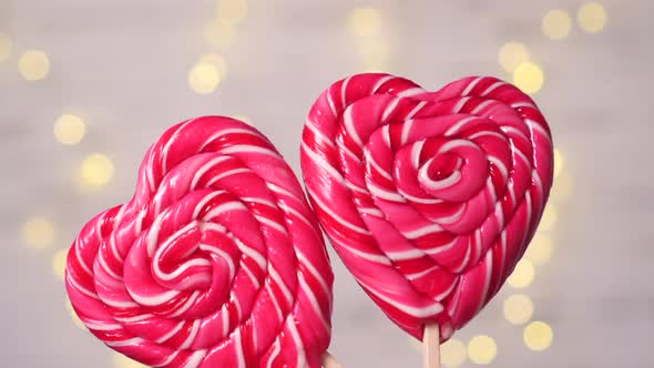 Two Heartshaped Candies Move Against the Background of Lights alt