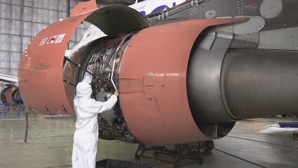 Engineer checks the engine of the aircraft. The repair of aircraft in the hangar alt
