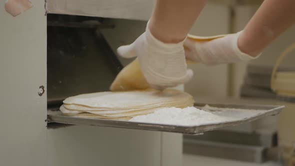 the Baker's Hands in Gloves Fold the Blanks of Dough Cakes Rolled By a Special Machine alt