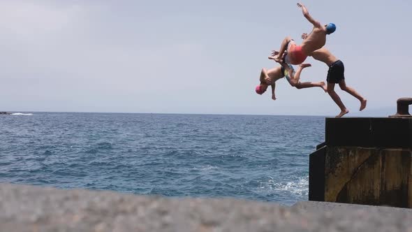 group of three people adult enjoying summer together at the beach running to the water alt