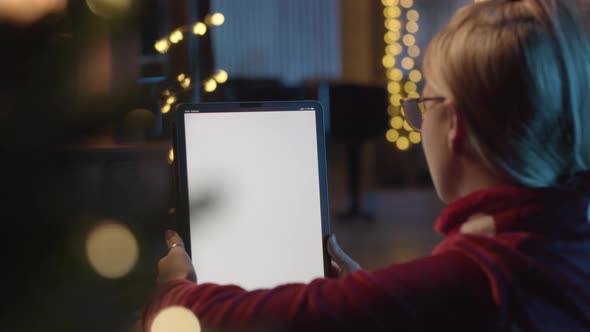 Back View of Woman Using Digital Tablet During Christmas Time