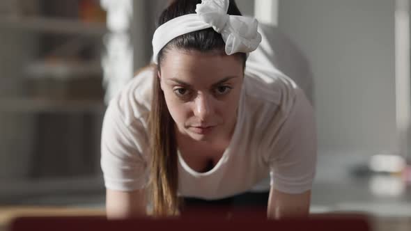 Positive Concentrated Pregnant Woman Exercising Online at Home Indoors in the Morning alt