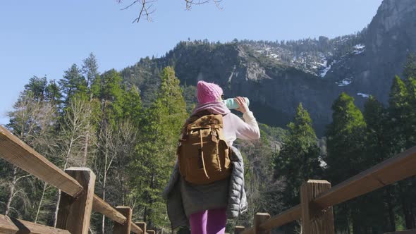 Backpacker Traveler Hiking in Yosemite Back View Woman Walking By Wooden Bridge alt