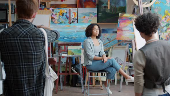 African-American Girl Model Posing for Group of Art Students in Modern Studio alt