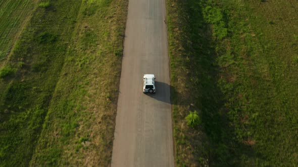 Aerial View of a Car Driving on a Country Road