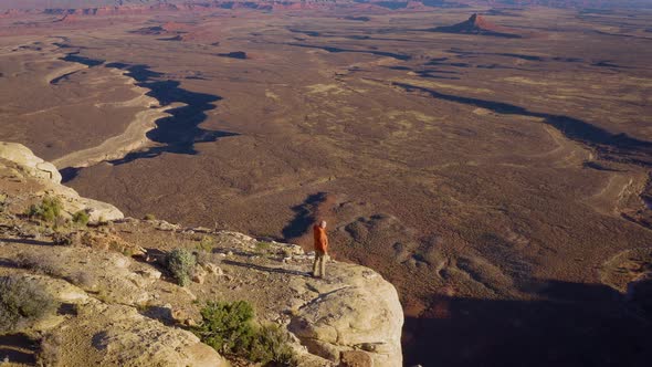 Aerial shot of a hiker at the the edge of Cedar Mesa in Utah alt