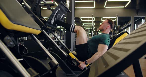 A Young Pumped Up Athlete Does Another Leg Exercise In The Gym In Preparation For Competition. alt