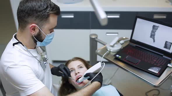 The Dentist Scans the Patient's Teeth with a 3d Scanner