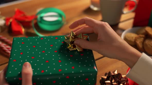 Hands Packing Christmas Gift and Choosing Bow alt