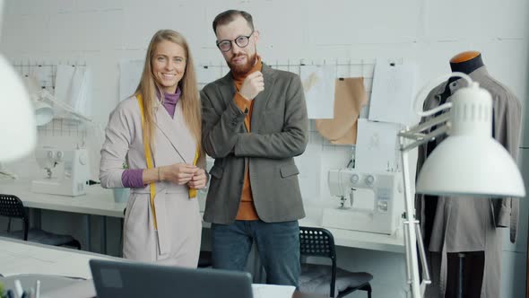 Portrait of Tailors Male and Female Smiling Indoors in Modern Sewing Studio alt