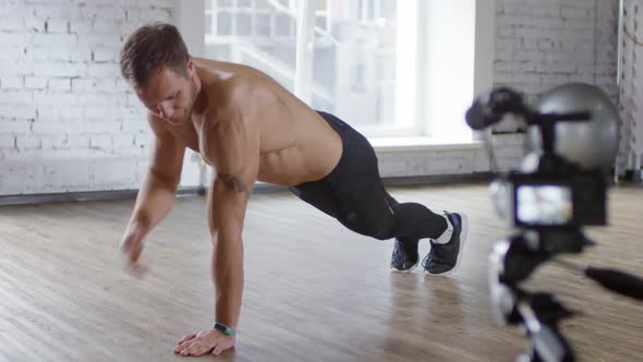 Shirtless Male Coach Explaining How to Do Push-Ups on Camera alt