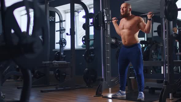 Young Fit Man Bodybuilder Doing Barbell Squats at Gym