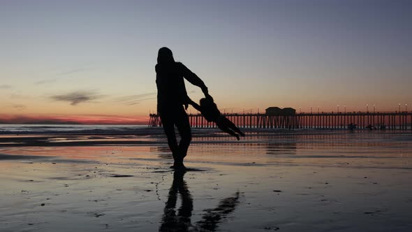 Father and Child Enjoy a Spin at the Beach