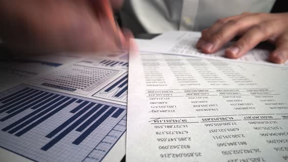 Accountant Analyzing Business Marketing Data on Paper Dashboard at Office Table alt