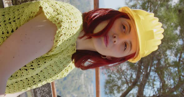 Vertical video of a girl architect who looks at the view from a mountain alt