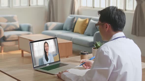 Asian Doctor Talking To Woman Patient Over Laptop Video Chat alt