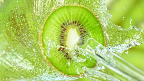 Super Slow Motion Shot of Splashing Water on Rotating Kiwi Slice at 1000Fps alt
