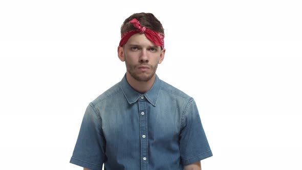Young Gloomy Guy with Red Bandana Looking Upset Sighing and Crossing Arms Over Chest Standing Uneasy