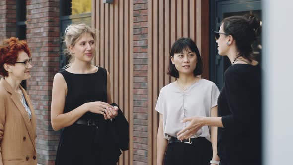 Young Diverse Businesswomen Having Discussion on City Street alt