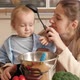 Happy Smiling Mother Playing with Ladle and Her Baby Son While Cooking on Kitchen - VideoHive Item for Sale