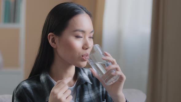 Asian Race Woman Take Drug Remedy Drinking Glass of Still Water Indoors at Home alt