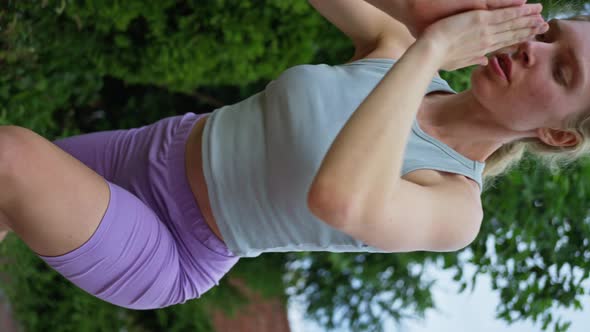 Blonde Woman Trains in the Evening Does Yoga Slow Motion Vertical View alt