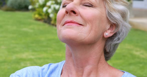 Senior woman performing yoga in garden alt