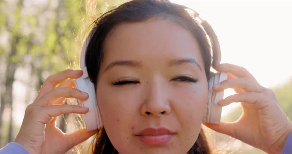 Asian Woman Listening to Music with Headphones alt