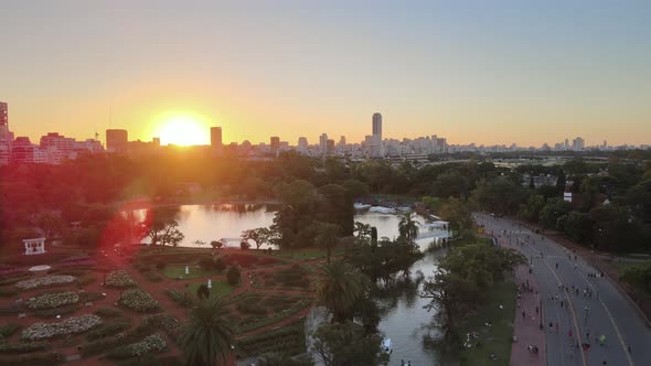 Aerial dolly in flying over Rosedal gardens pond near Palermo Woods pedestrian street at sunset, Bue alt