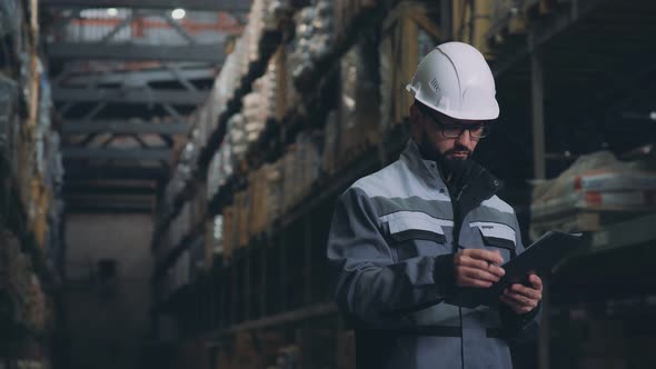The Warehouse Worker in Gray Uniform Carries out an Audit