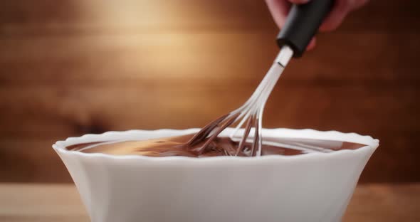 Closeup Chocolatier Mixing Melted Liquid Chocolate with Steel Whisk alt