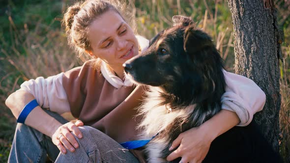 Portrait of a Young Adult Woman Stroking Her Cute Shaggy Dog alt