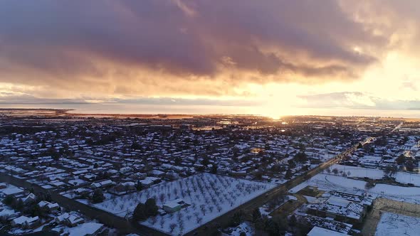 Hyper lapse flying backwards over snow covered town and intersection alt