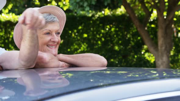 Senior couple leaning on car alt