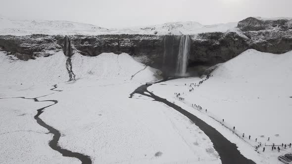 Aerial view of Seljalandsfoss waterfall in Iceland covered by snow