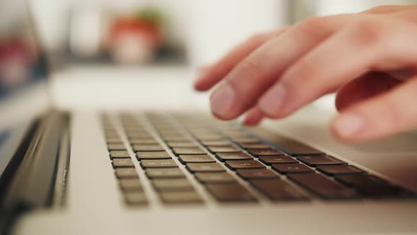 Close Up of a Person's Hands Typing on a Laptop Keyboard Indoors alt